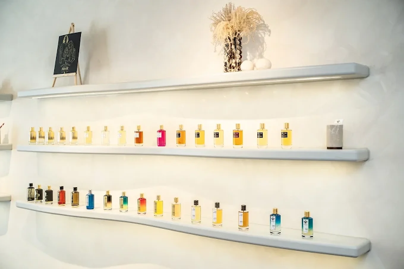 Twee verlichte planken met de parfums van Mancera